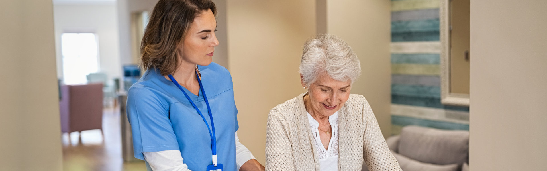 elderly woman walking in the hallway with her caregiver